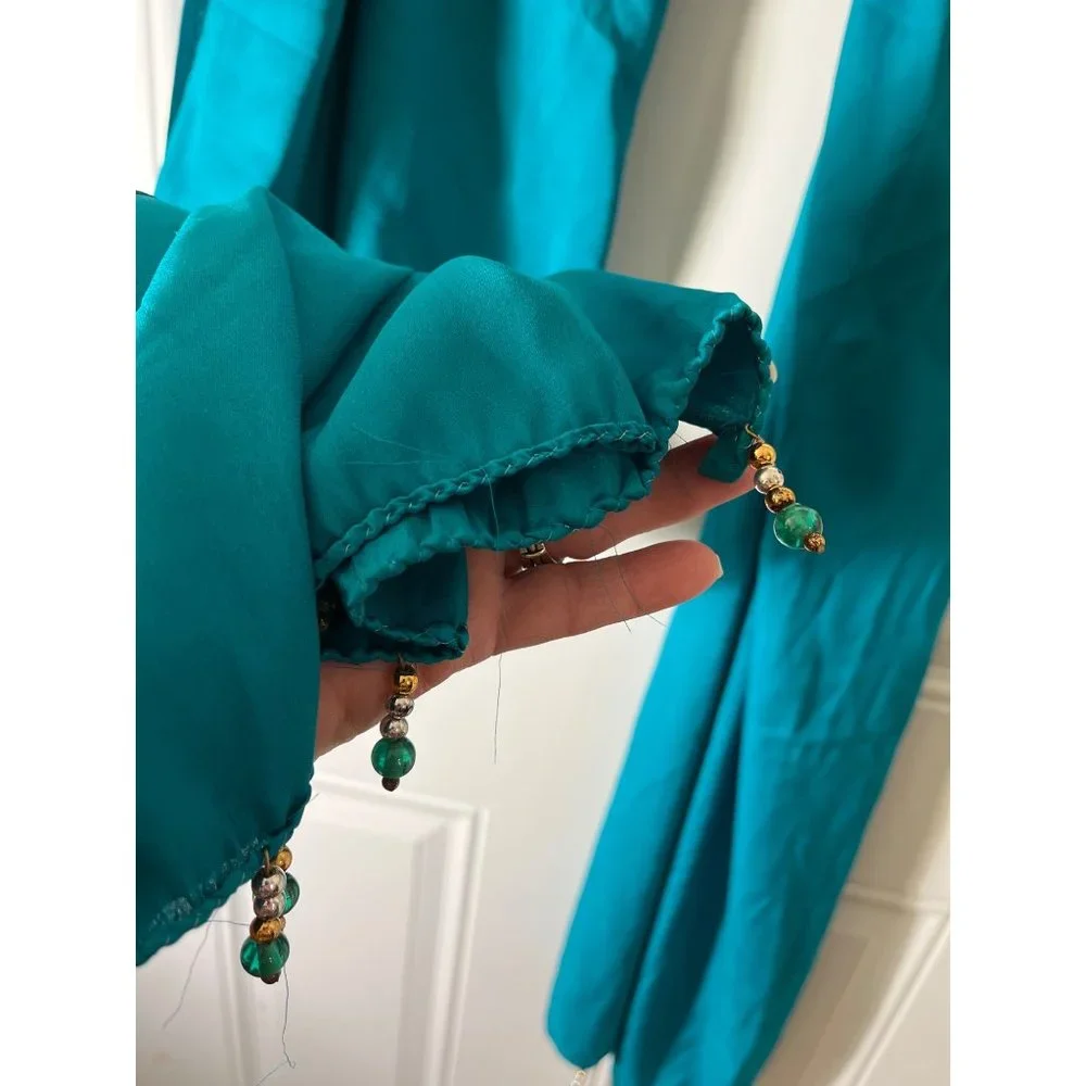 Teal colored shawl wrap with teal, silver, and gold beads on ends